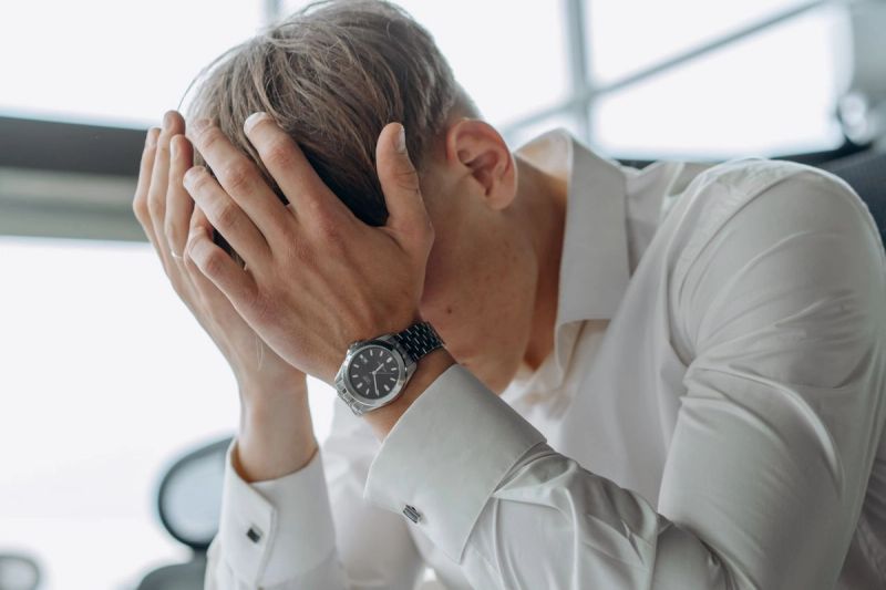 man stressed with head in his hands