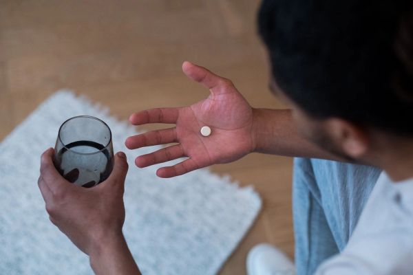 man holding pill in hand