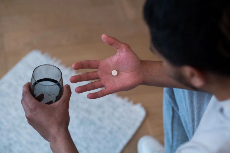 man holding pill in hand