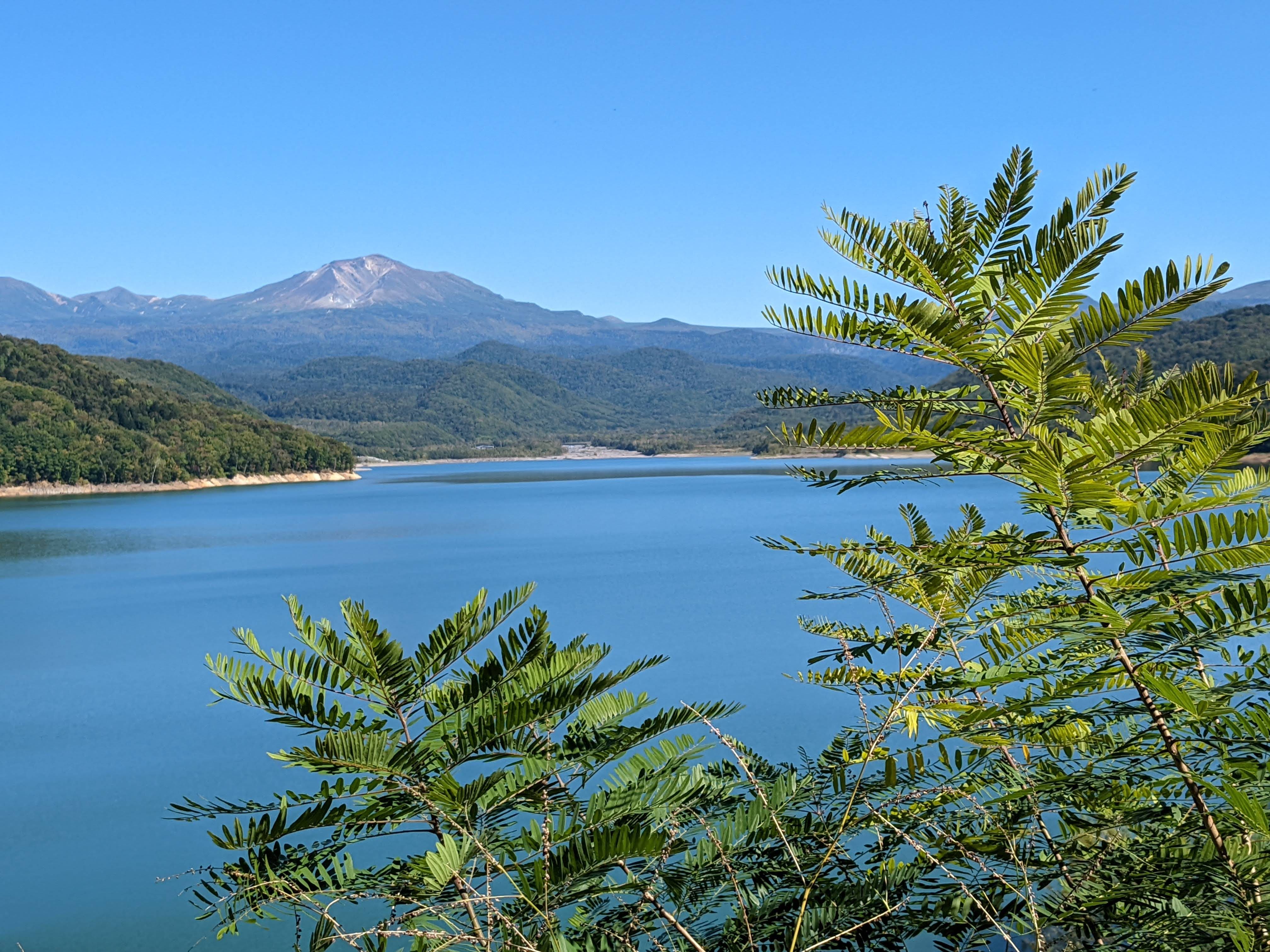 A clear view on a bright, sunny day of Mt. Asahidake from the shores of Lake Chubetsu in midsummer.