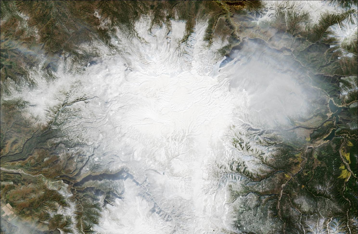 A satellite image showing snow over the northern Daisetsuzan mountains. Snow can be seen on the mountains while the valleys remain dark and snow free.