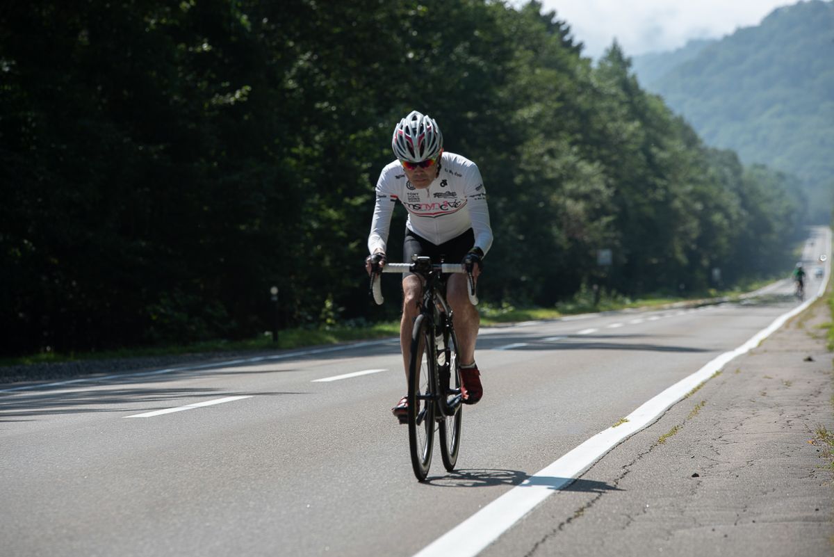 A cyclist looks a head as they ride up a hill