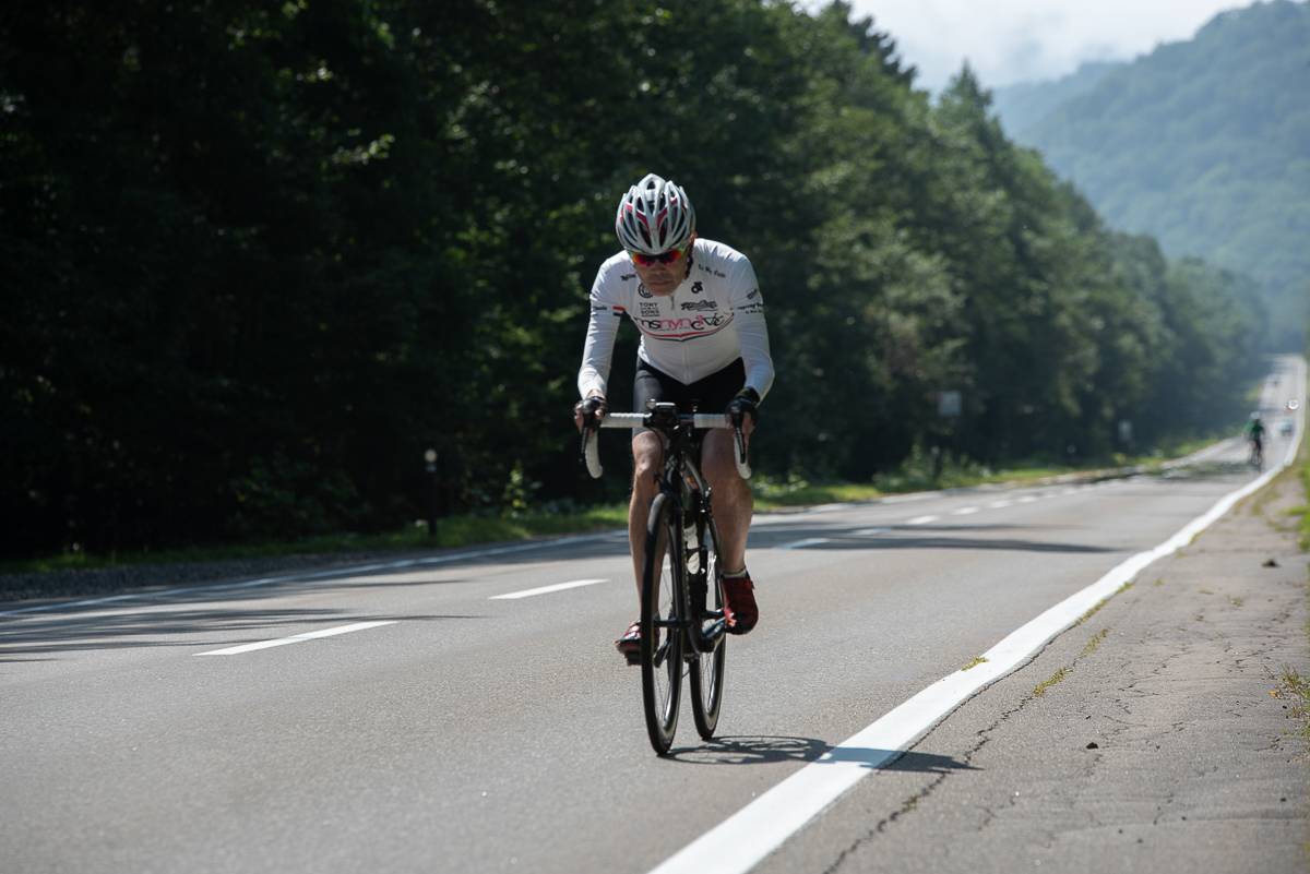 A cyclist looks a head as they ride up a hill
