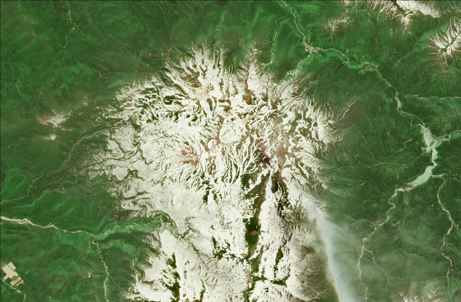 A satellite image showing snow over the northern Daisetsuzan mountains. Strips of snow remain in the mountains while the rest of the landscape is green.