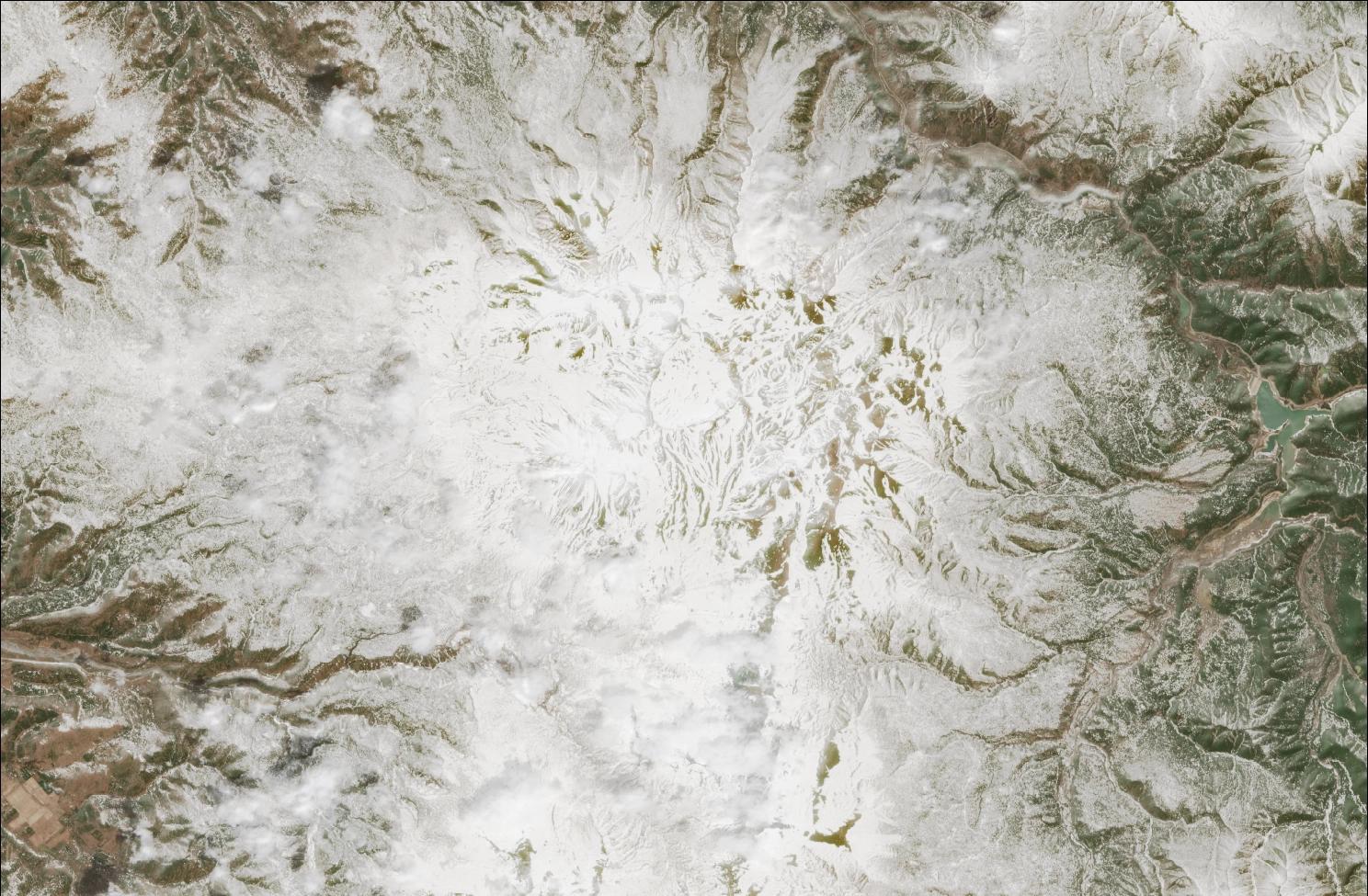 A satellite image showing snow over the northern Daisetsuzan mountains. The landscape is mostly white, while exposed ridges and low valleys have no snow.