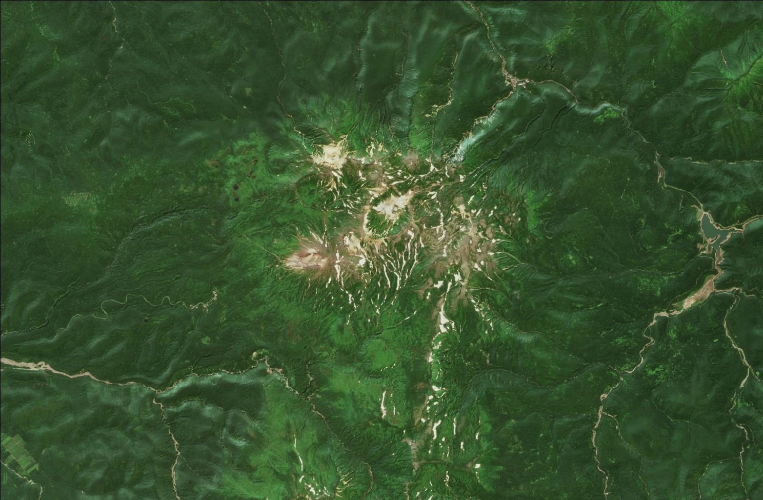 A satellite image showing snow over the northern Daisetsuzan mountains. Strips of snow remain in the mountains while the rest of the landscape is green.
