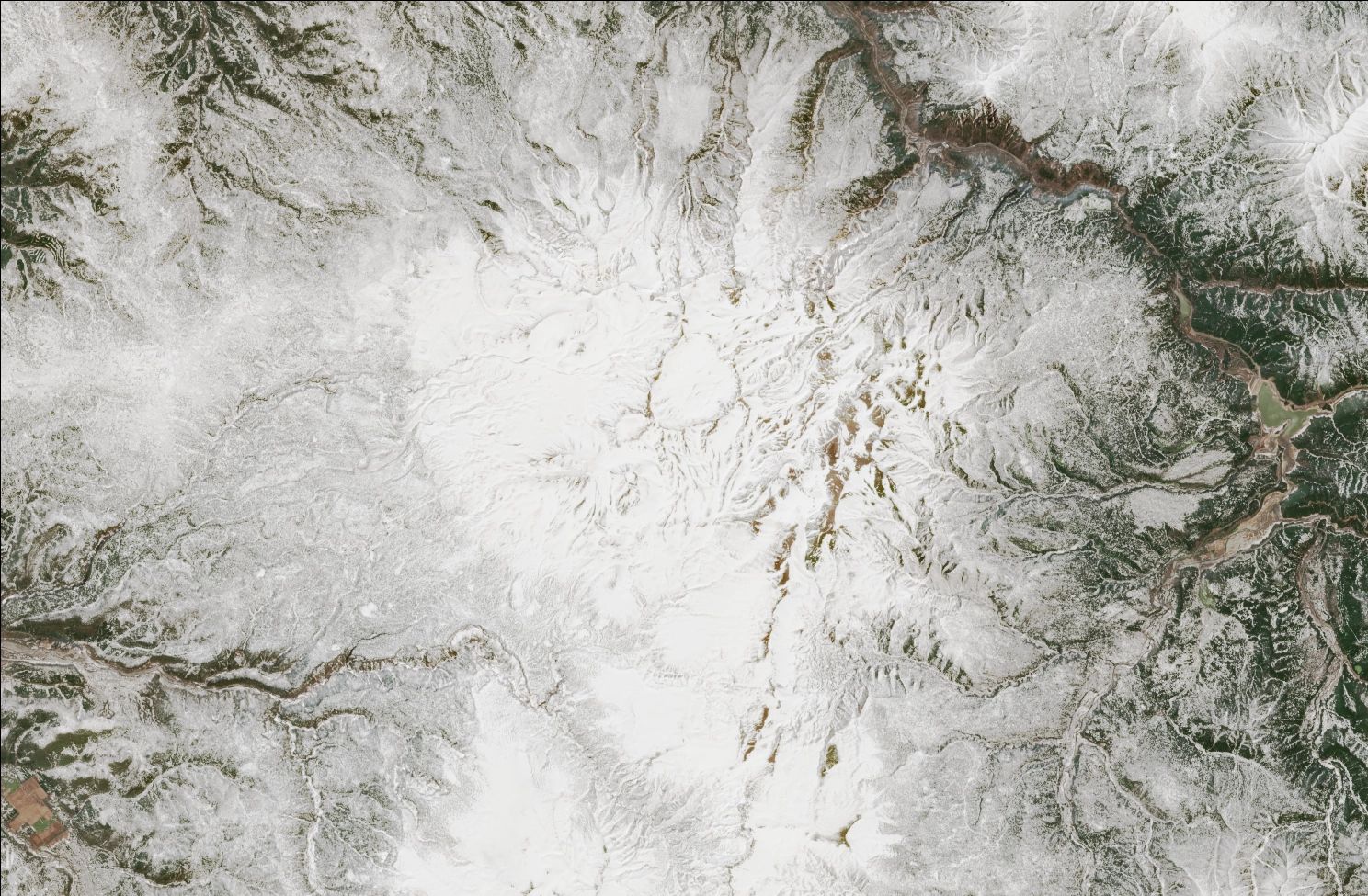 A satellite image showing snow over the northern Daisetsuzan mountains. The landscape is mostly white, while exposed ridges and low valleys have no snow.