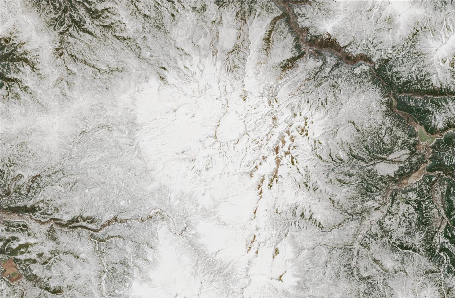 A satellite image showing snow over the northern Daisetsuzan mountains. The landscape is mostly white, while exposed ridges and low valleys have no snow.