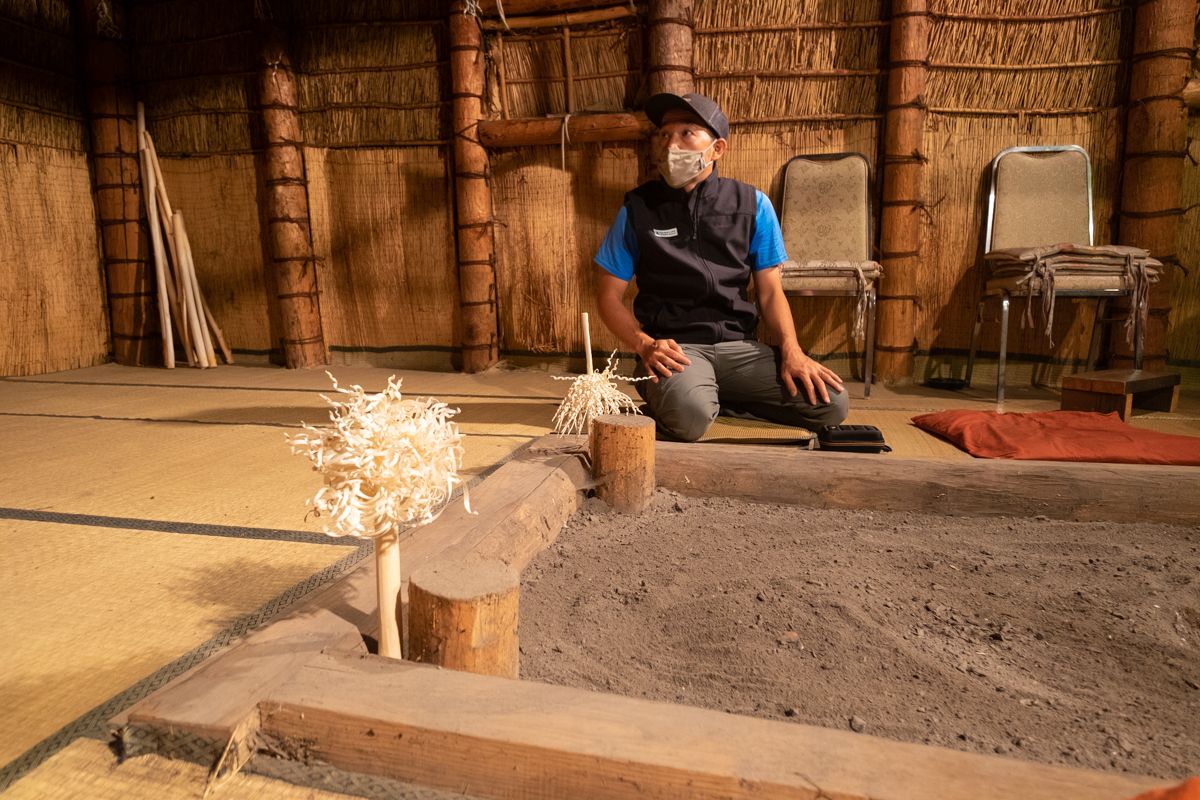 A cycle guide sits in a Cise, a traditional Ainu house
