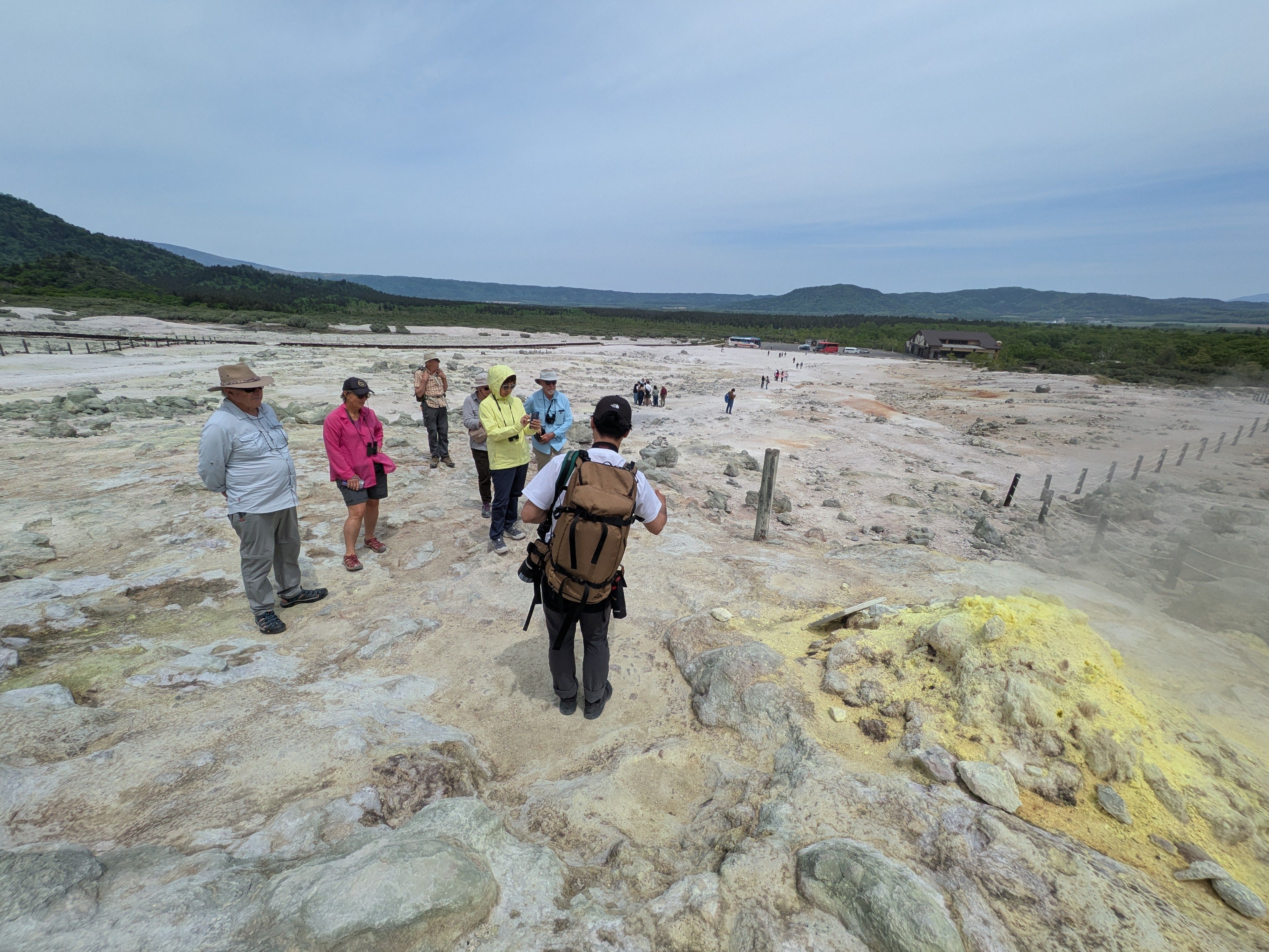 A group of people admire a sulphuric vent on Mt. Io, an active volcano in east Hokkaido. The vent is neon yellow and smells like bad eggs!