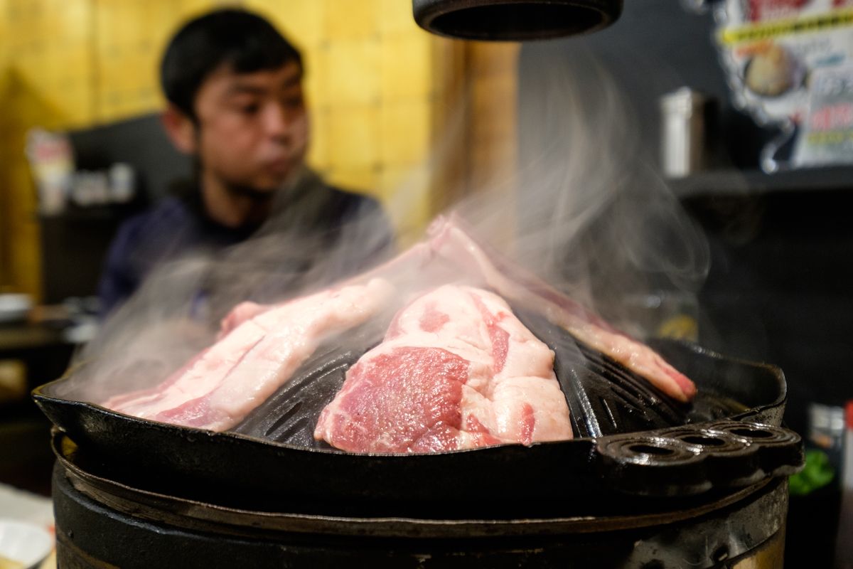 Mutton meat smokes on a grill