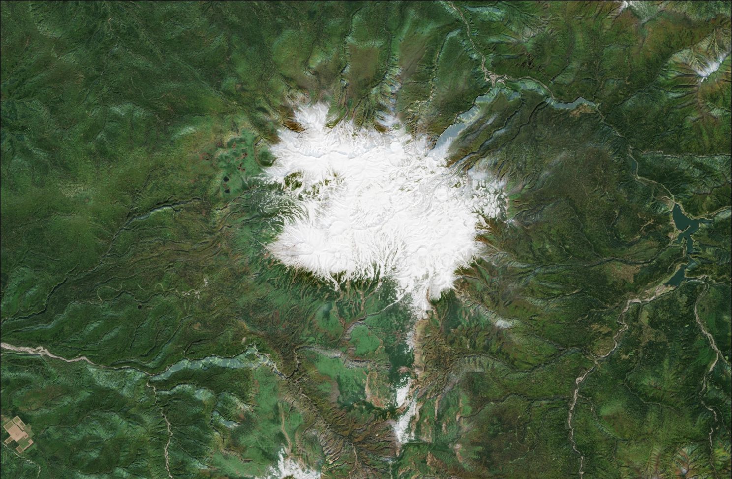 A satellite image showing snow over the northern Daisetsuzan mountains. The mountains in the centre of the image have snow, while the rest of the landscape is green.