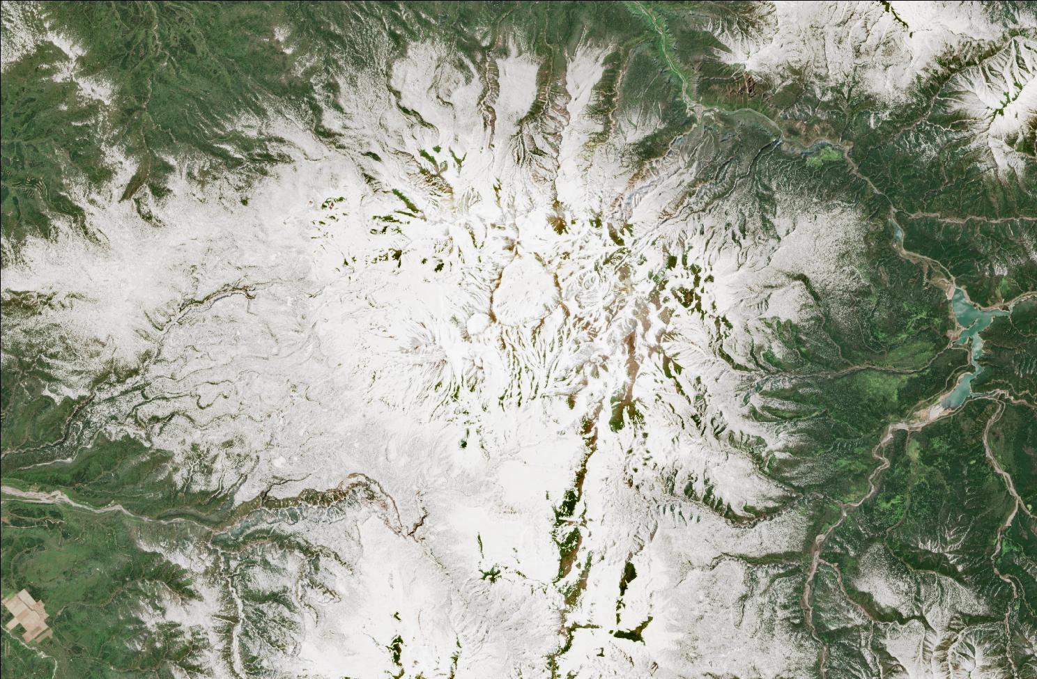 A satellite image showing snow over the northern Daisetsuzan mountains. The landscape is mostly white, while exposed ridges and low valleys have no snow.