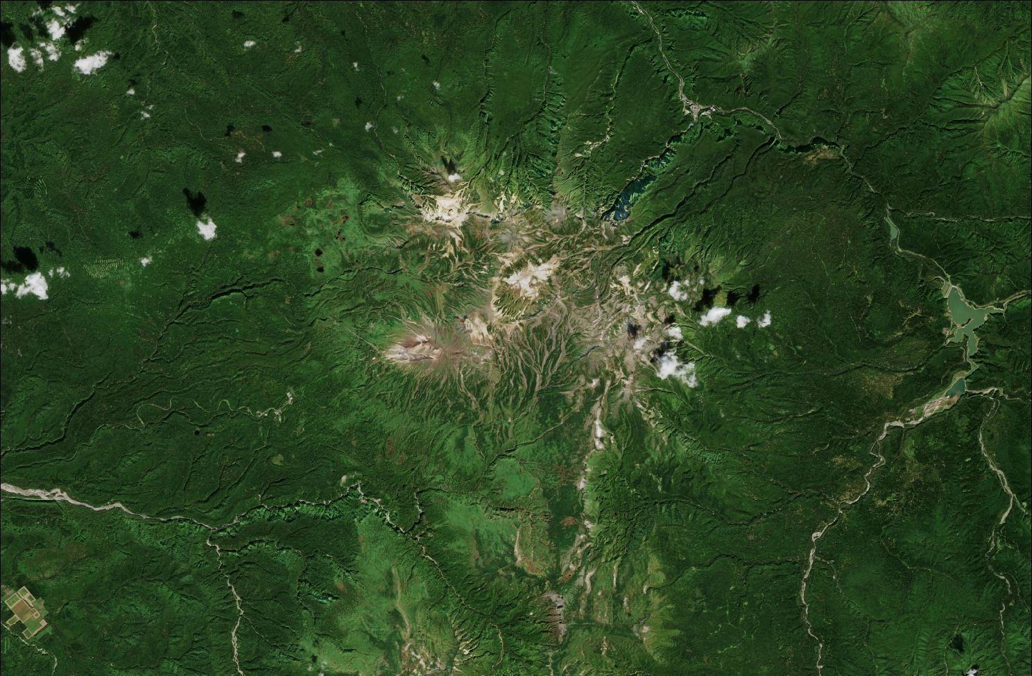 A satellite image showing the northern Daisetsuzan mountains. The upper mountains are rocky and bare while the rest of the landscape is green.