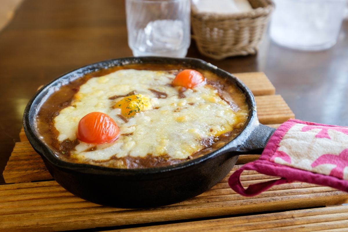 Grilled curry topped with cheese and served in a metal pan