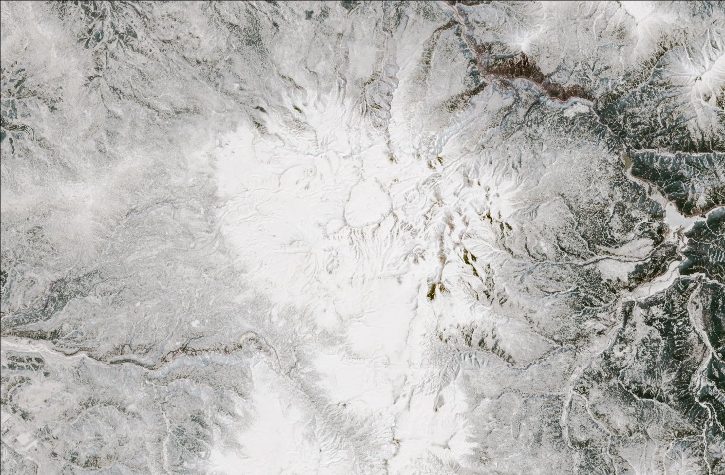A satellite image showing snow over the northern Daisetsuzan mountains. The landscape is mostly white, while exposed ridges and low valleys have no snow.