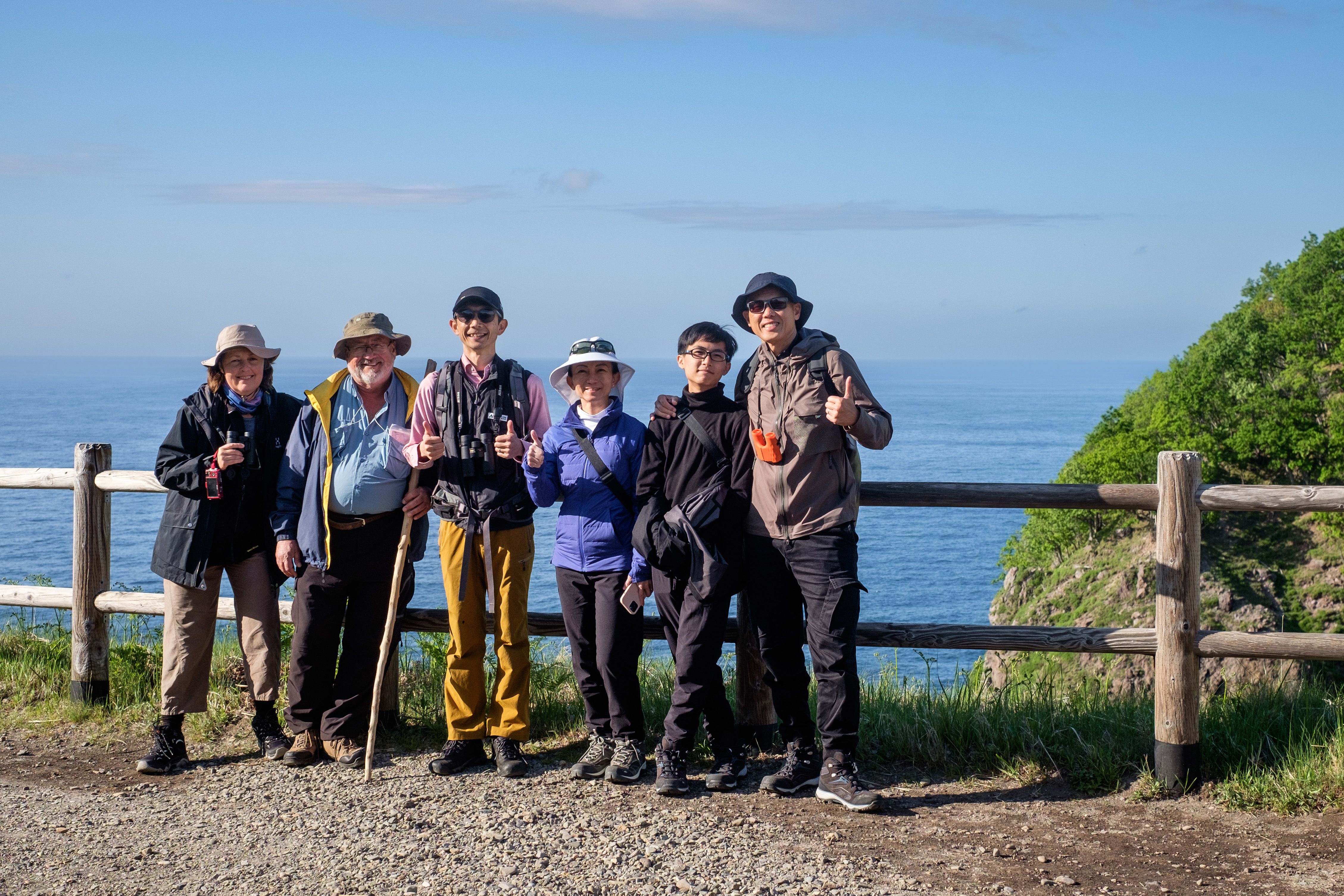 A group of tourists pose for a photo a Furuppe Waterfall in the Shiretoko National Park