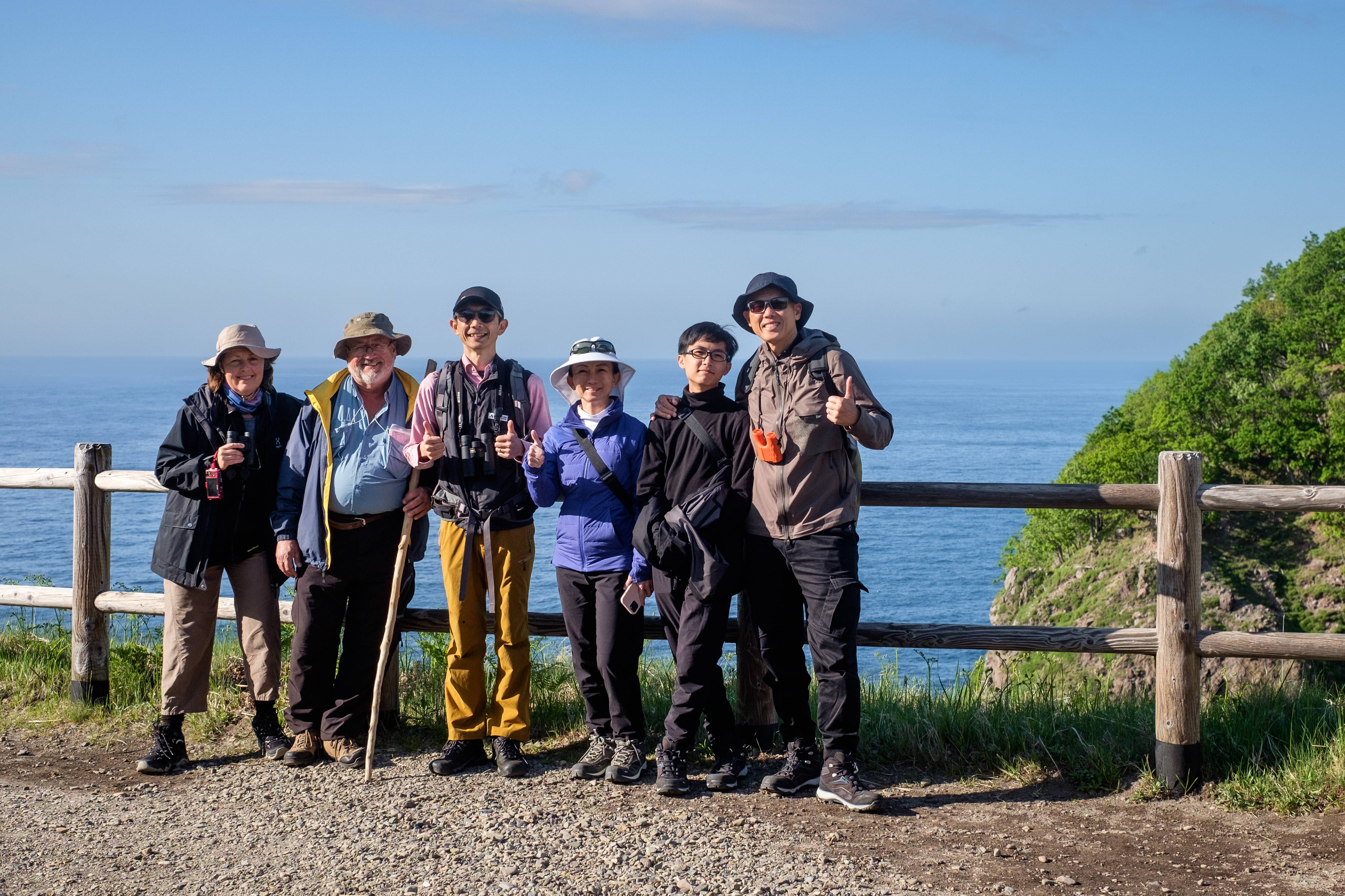 A group of tourists pose for a photo a Furuppe Waterfall in the Shiretoko National Park