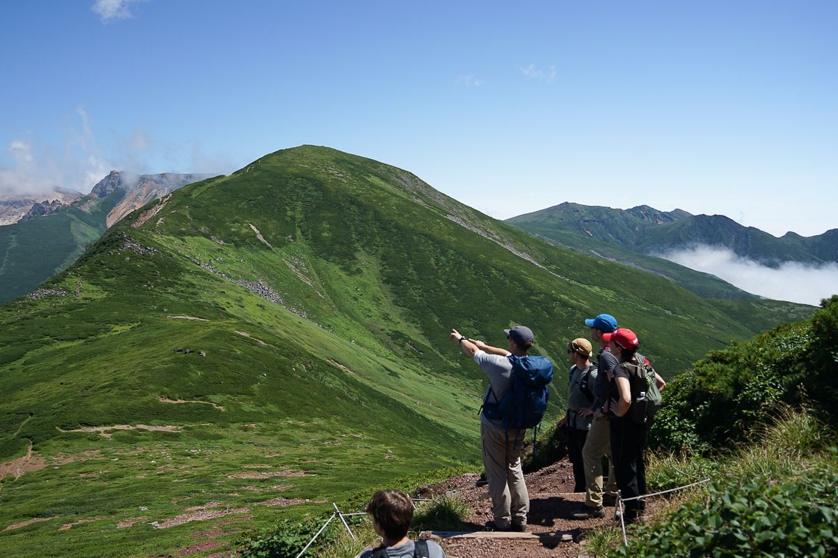 A hiking guide points out the volcanic steam on Mt. Tokachi