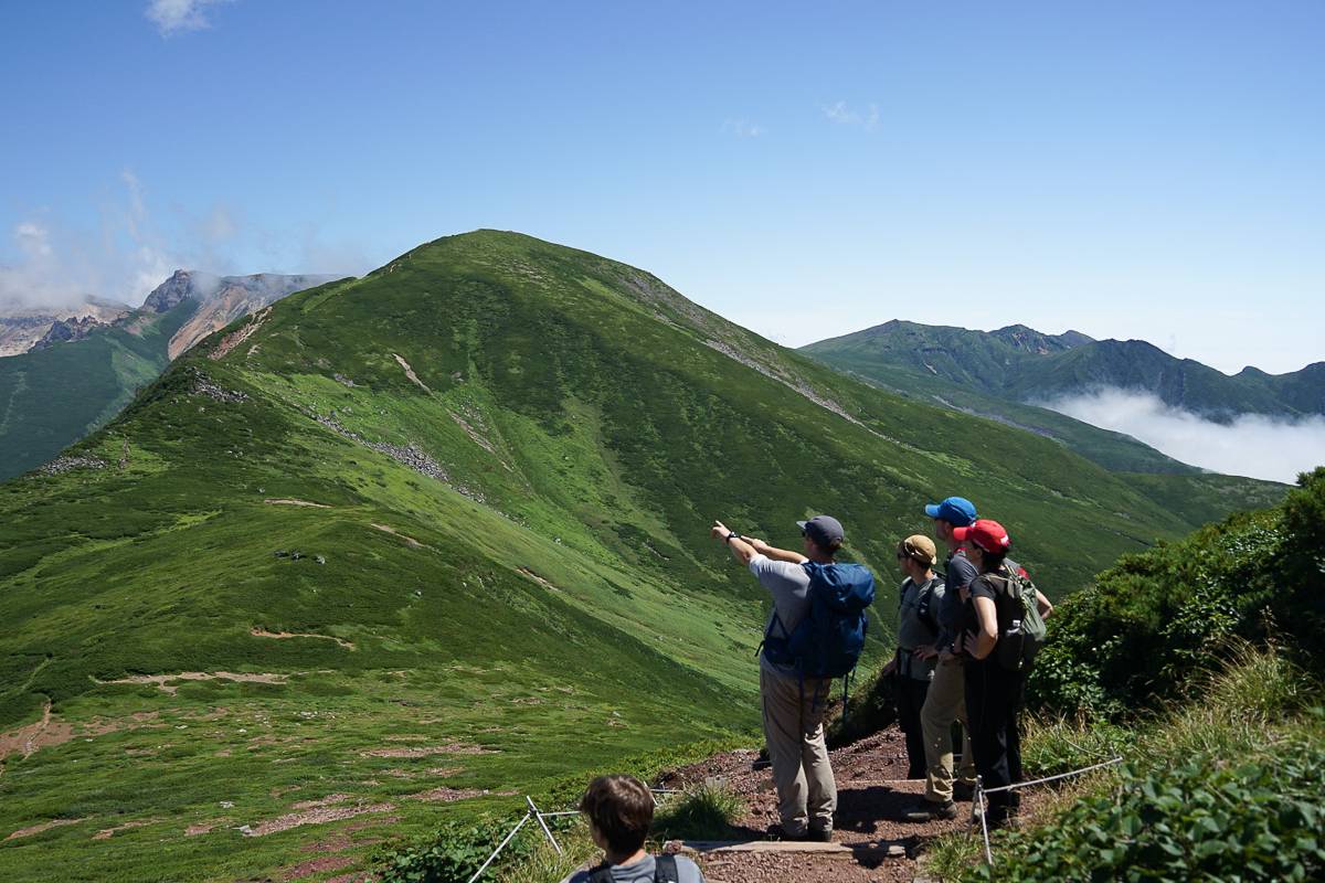 A hiking guide points out the volcanic steam on Mt. Tokachi