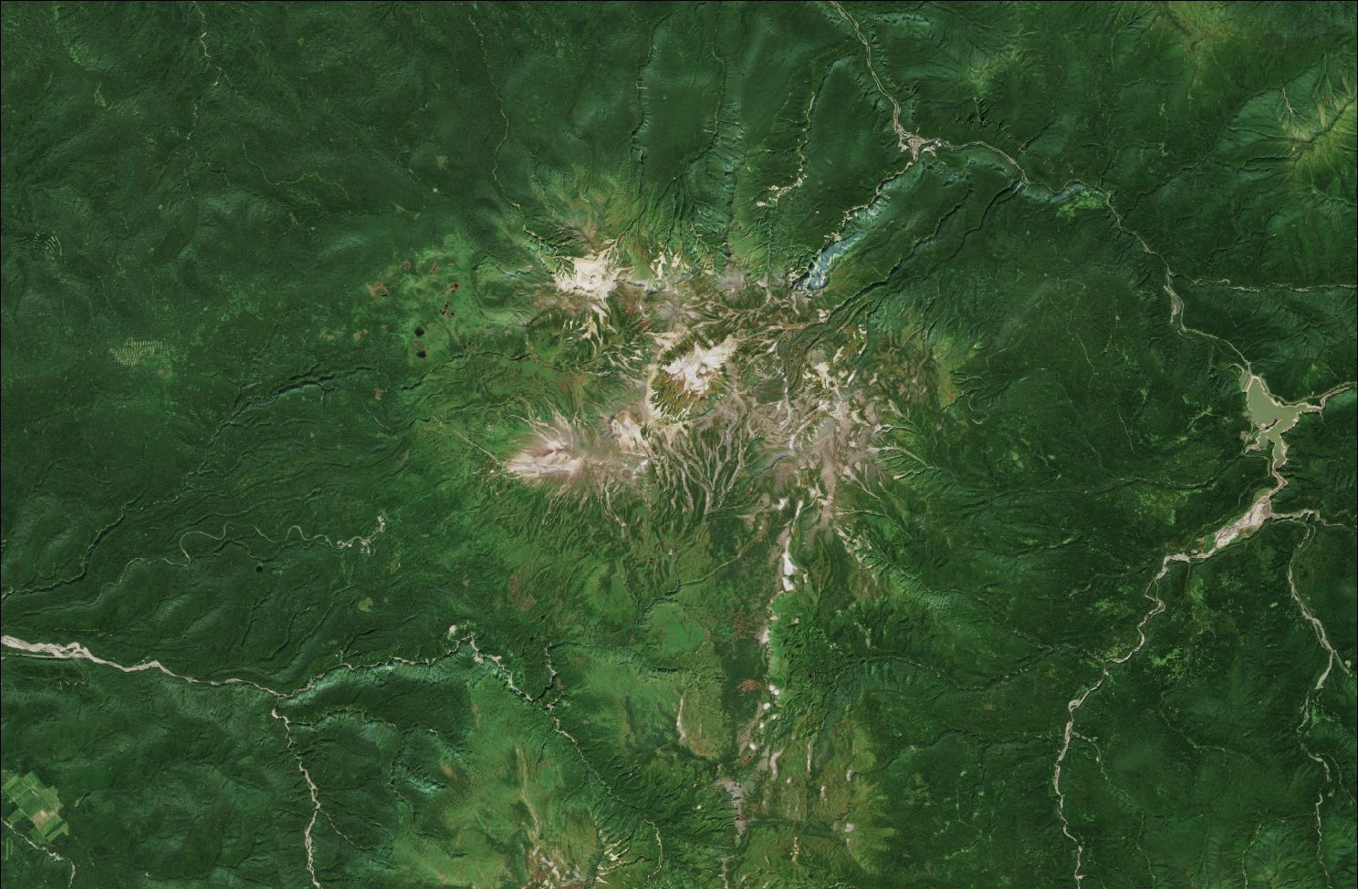 A satellite image showing the northern Daisetsuzan mountains. The upper mountains are rocky and bare while the rest of the landscape is green.