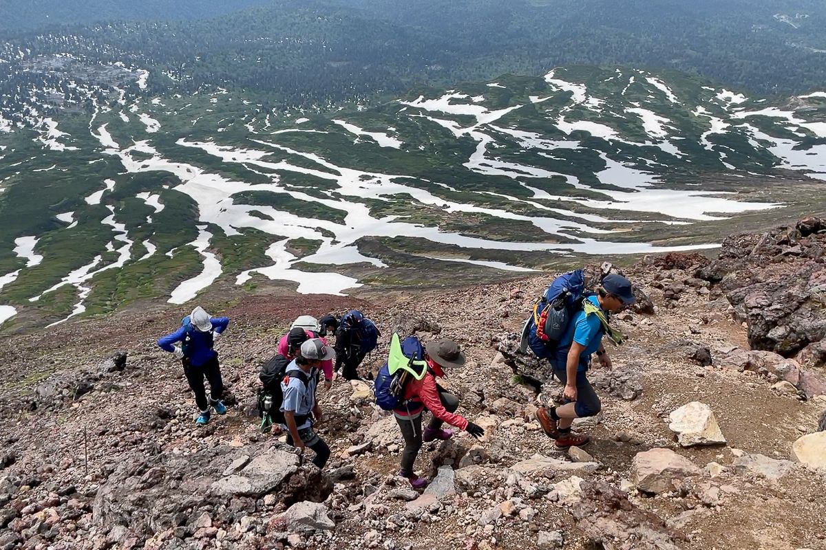 Hikers above the snowline on Mt Asahidake in Hokkaido