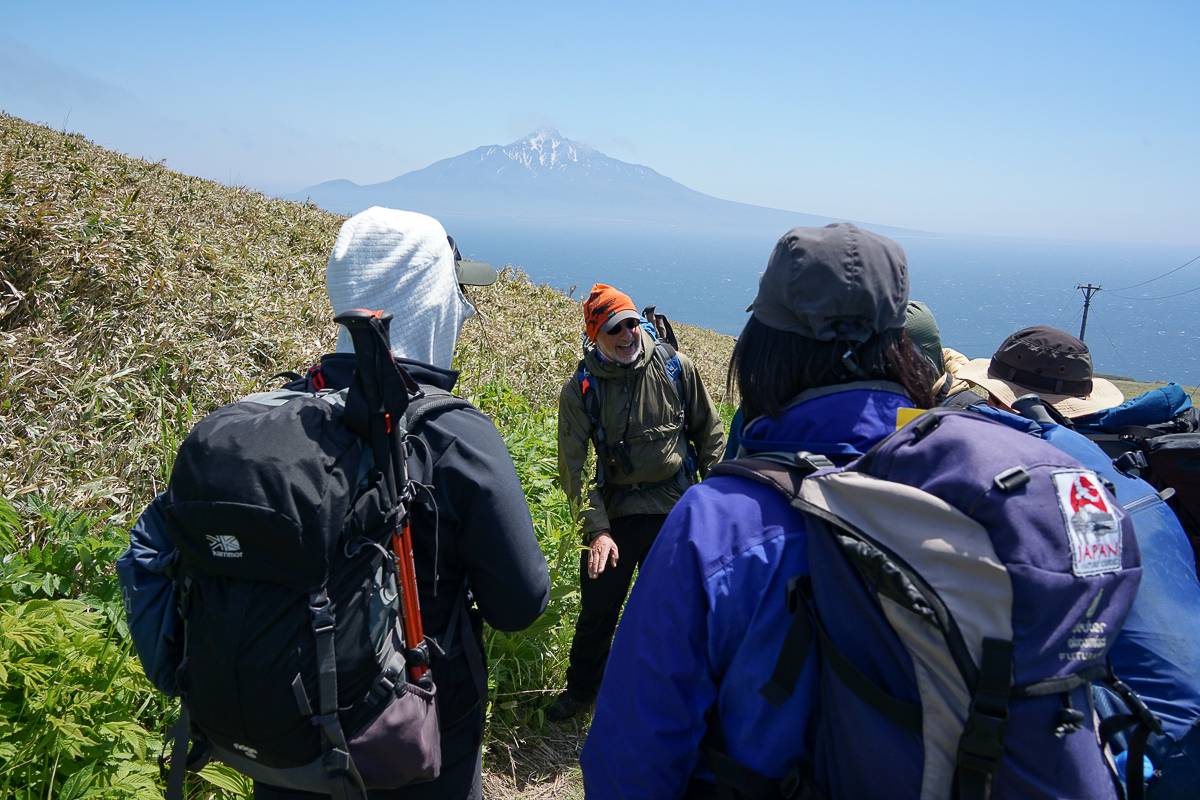 Dr Mark Brazil explains the plant life while Mt Rishiri is visible in the background