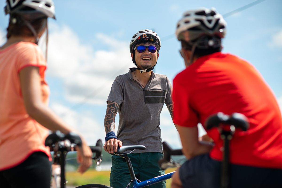 A cycling guide laughs while briefing a group of guests