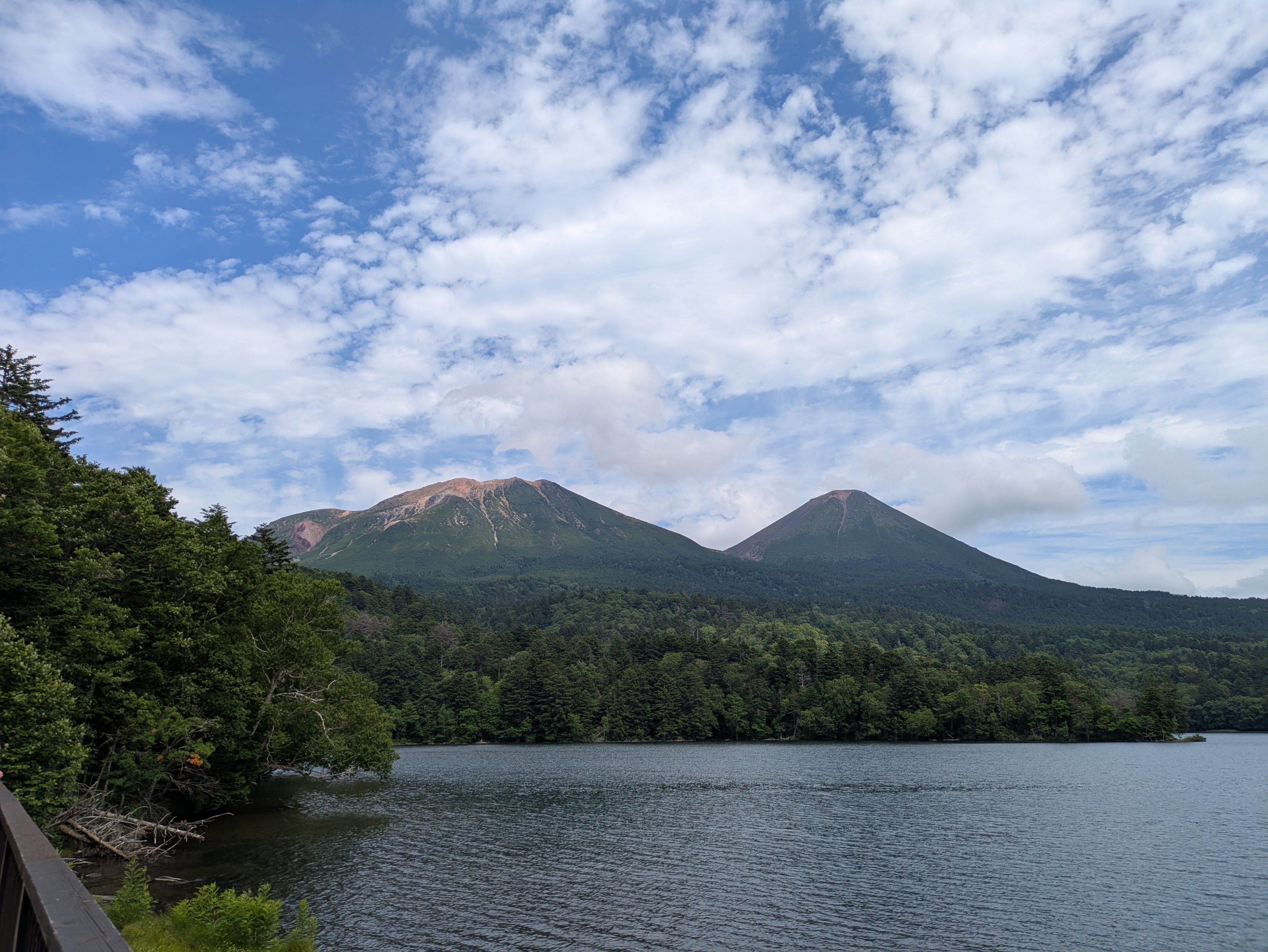 A photo of Lake Onneto on a sunny day. Mt. Meakan is clearly visible. It is a sunny day with blue skies and some clouds overhead.