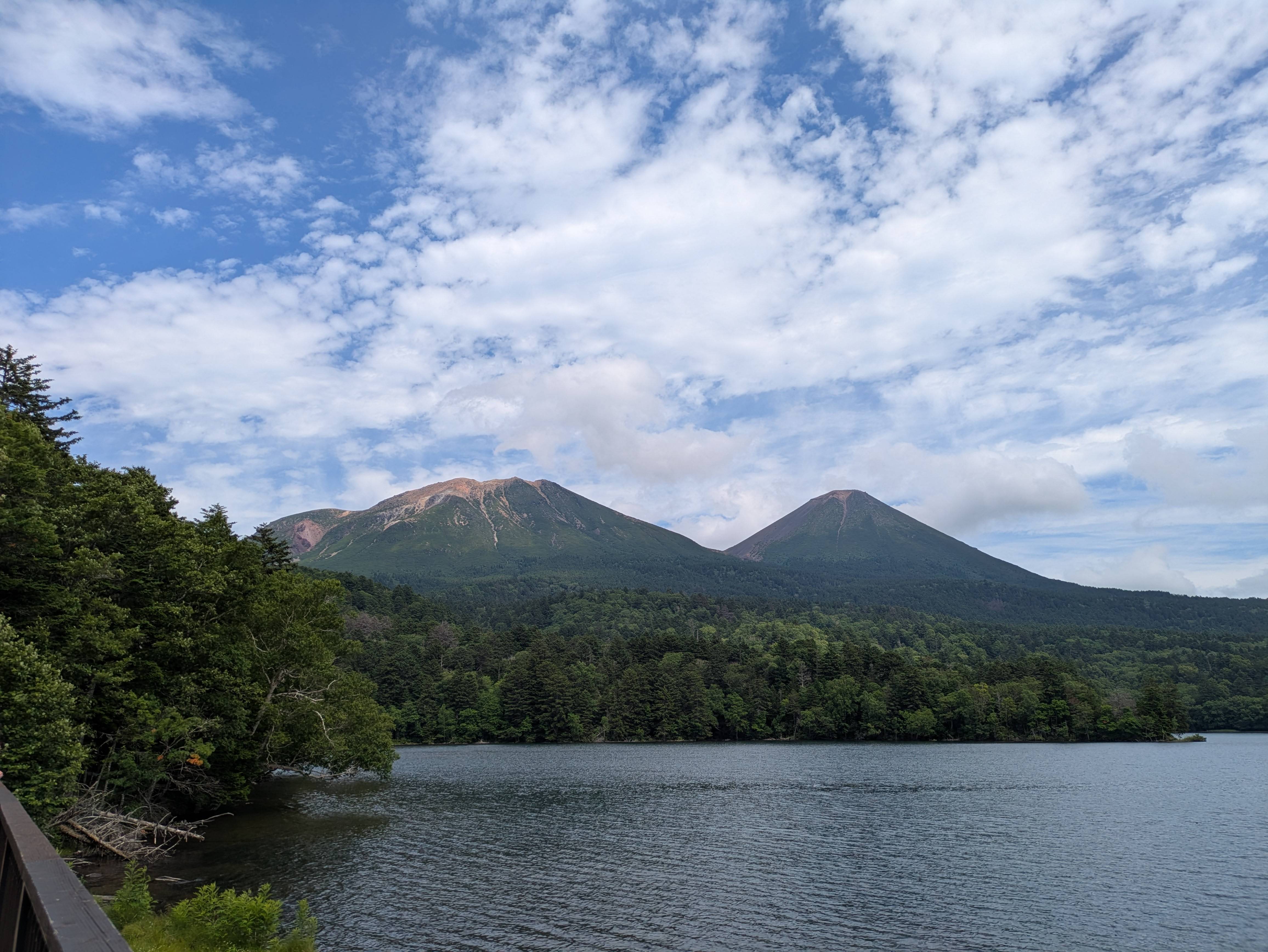 A photo of Lake Onneto on a sunny day. Mt. Meakan is clearly visible. It is a sunny day with blue skies and some clouds overhead.