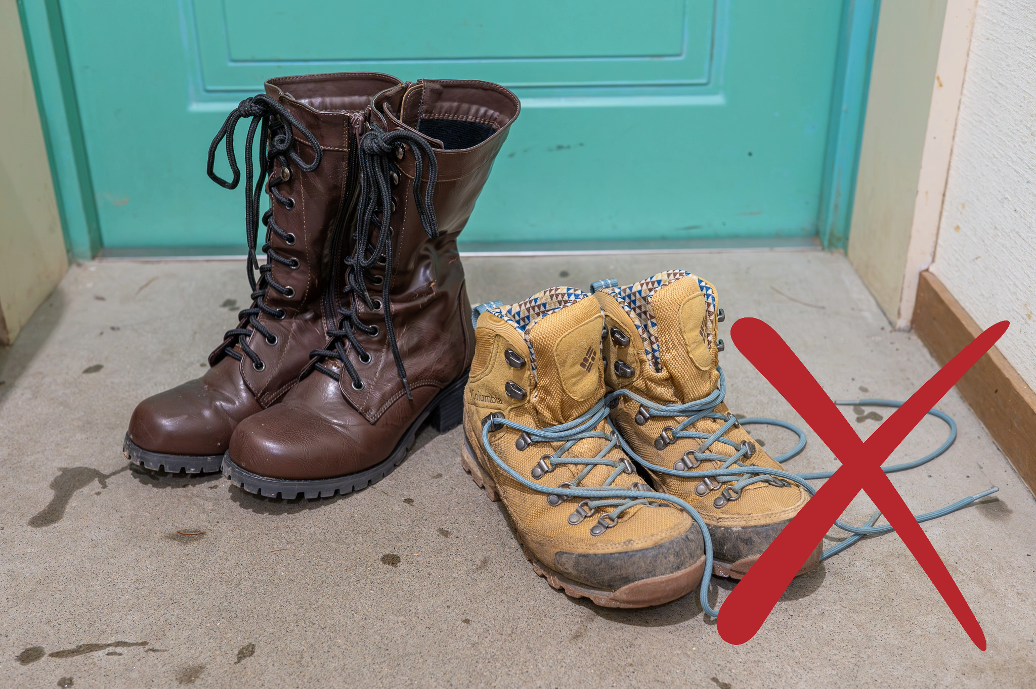 Two pairs of shoes on a concrete floor. One is a pair of hiking boots, the other are leather fashion boots.