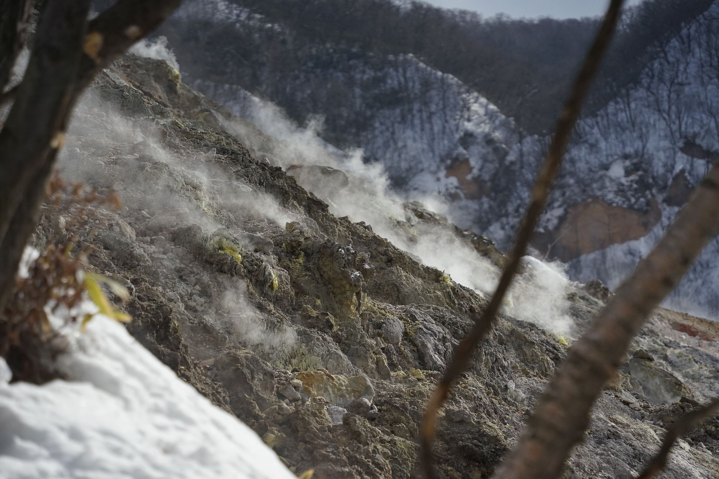 Bare rocks steaming at Noboribetsu Hell Valley in winter.