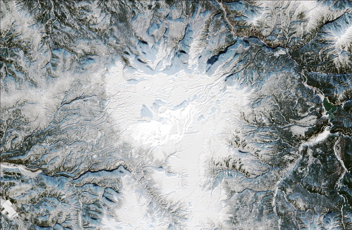 A satellite image showing snow over the northern Daisetsuzan mountains. Snow can be seen on the mountains while the valleys remain dark and mostly snow free.