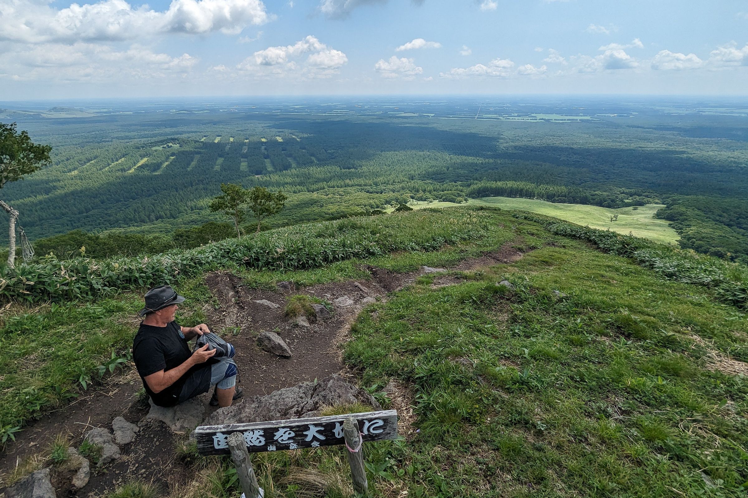A hiker overlooks East Hokkaido's sprawling forests from the top of Mt. Nishibetsu's Gaman Hill.