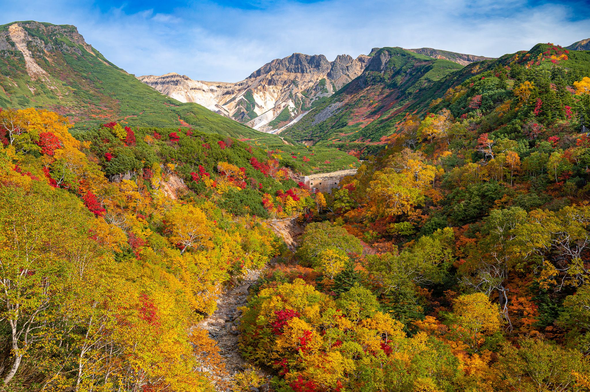 The view of autumn leaves and mountains from the observation deck at Tokachidake Onsen.