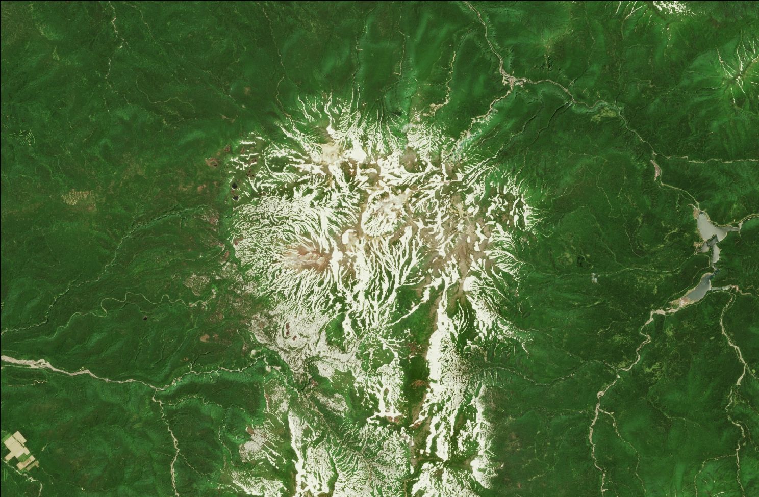 A satellite image showing snow over the northern Daisetsuzan mountains. Patches of snow remain in the mountains while the rest of the landscape is green.