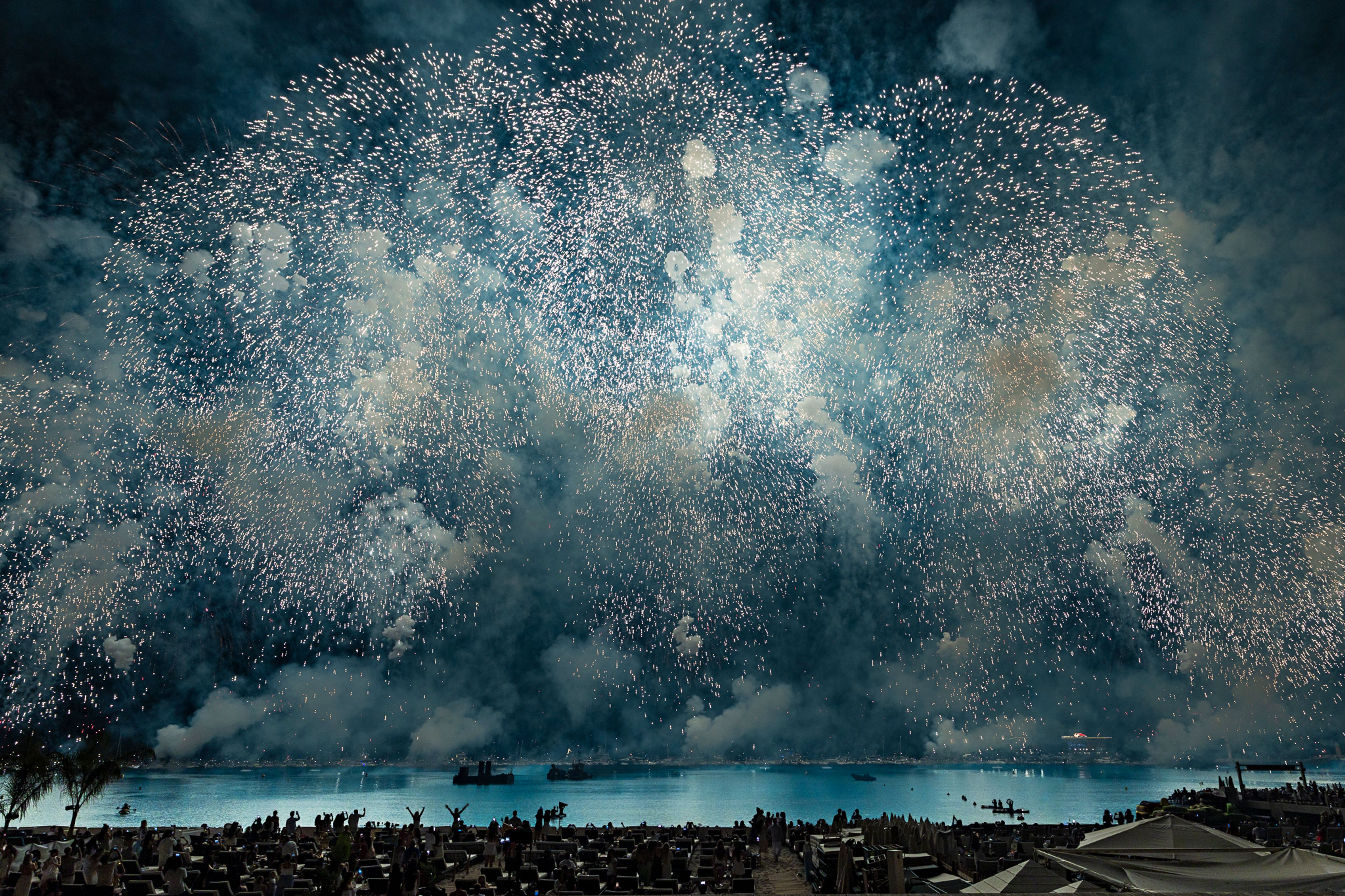 Silver fireworks filling the sky over the bay of Cannes.