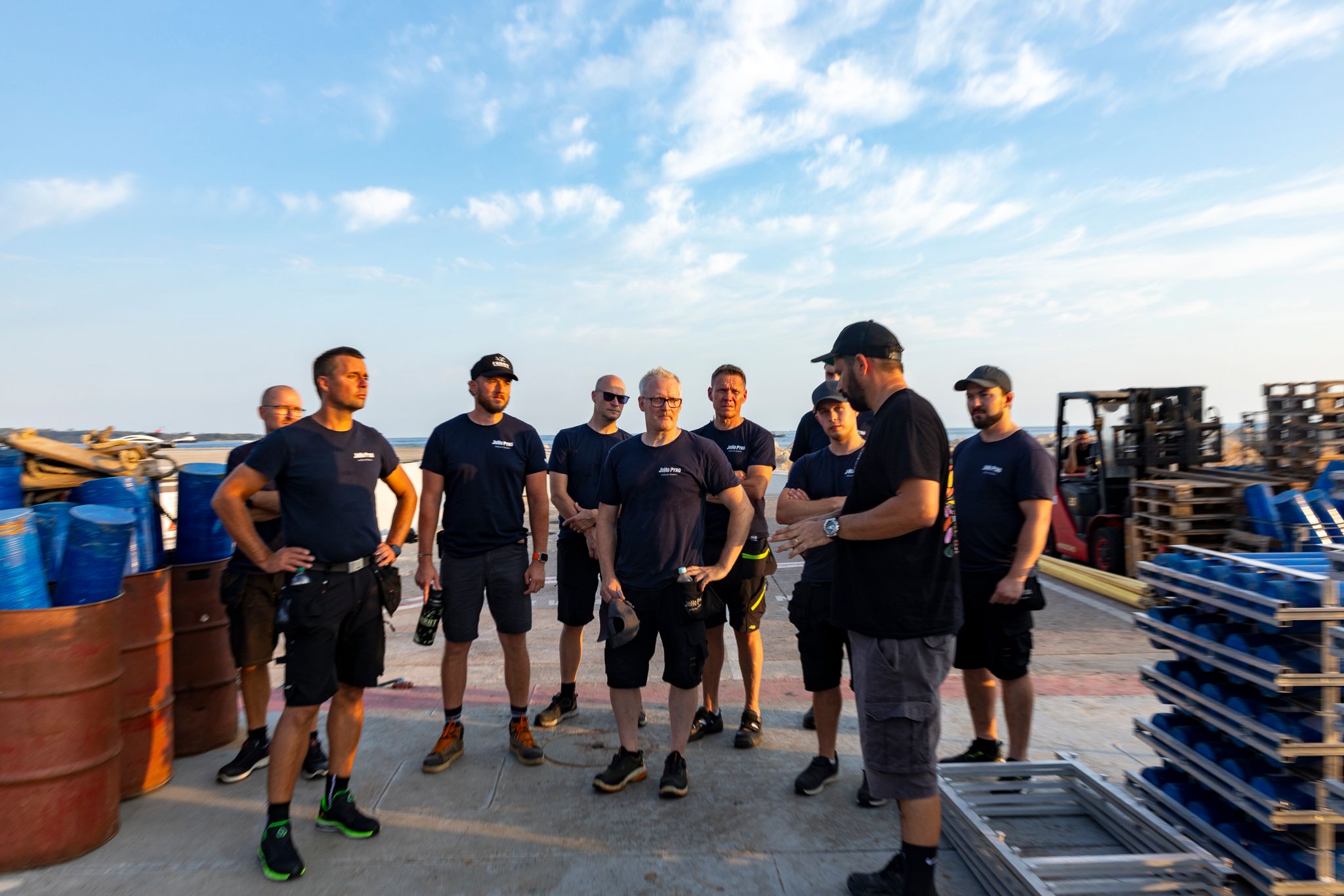 Members of the JoHo Pyro team talking together among equipment on the quay in Cannes.