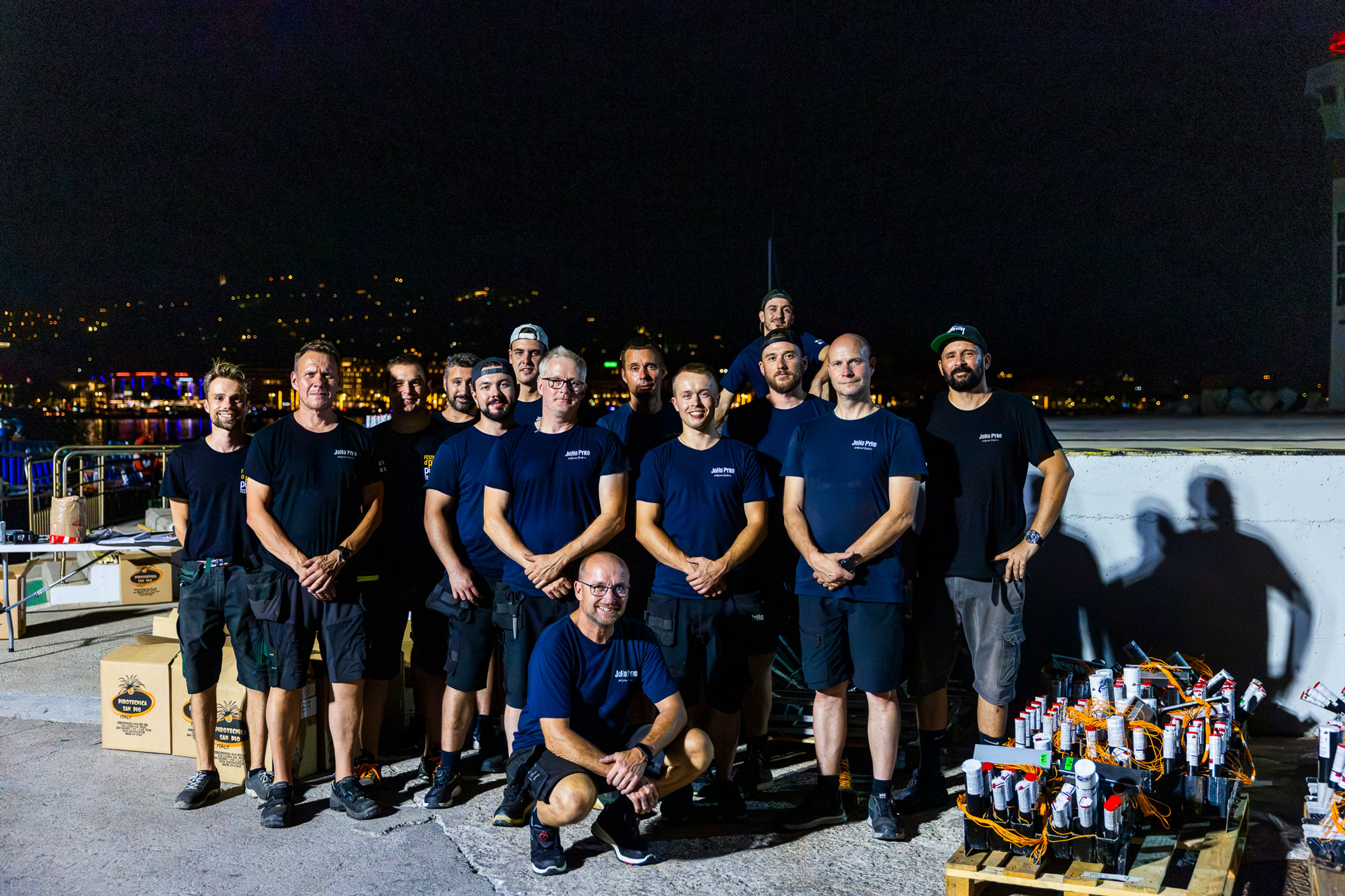 The JoHo Pyro team posing together at night on the quay in Cannes, beside their equipment.