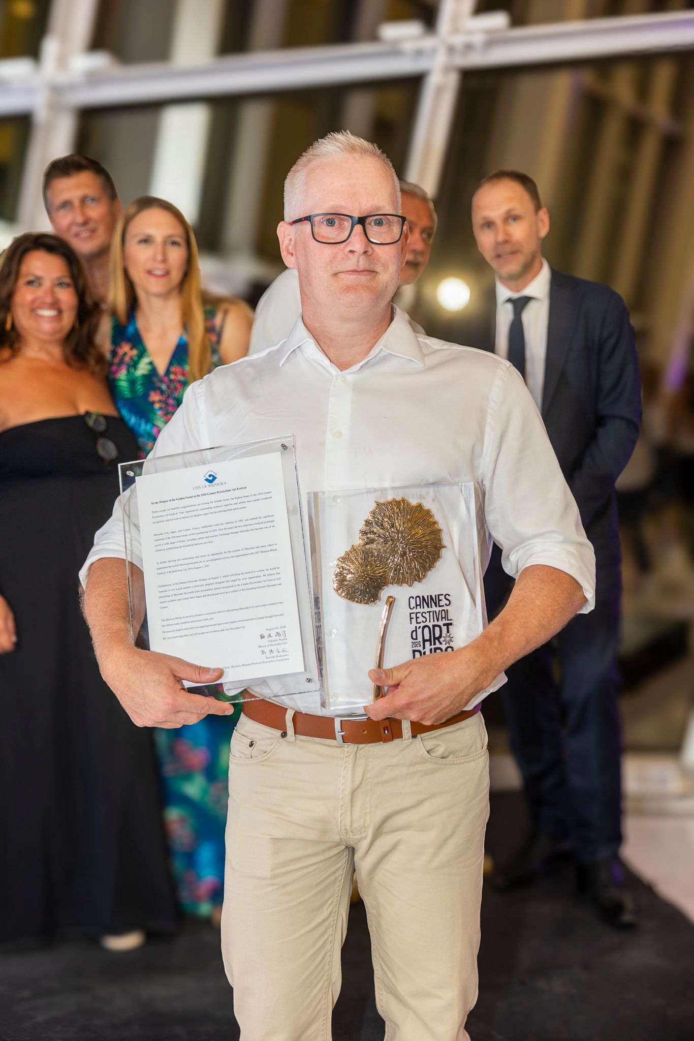 Johan Holländer holding a trophy and a framed document in Cannes.
