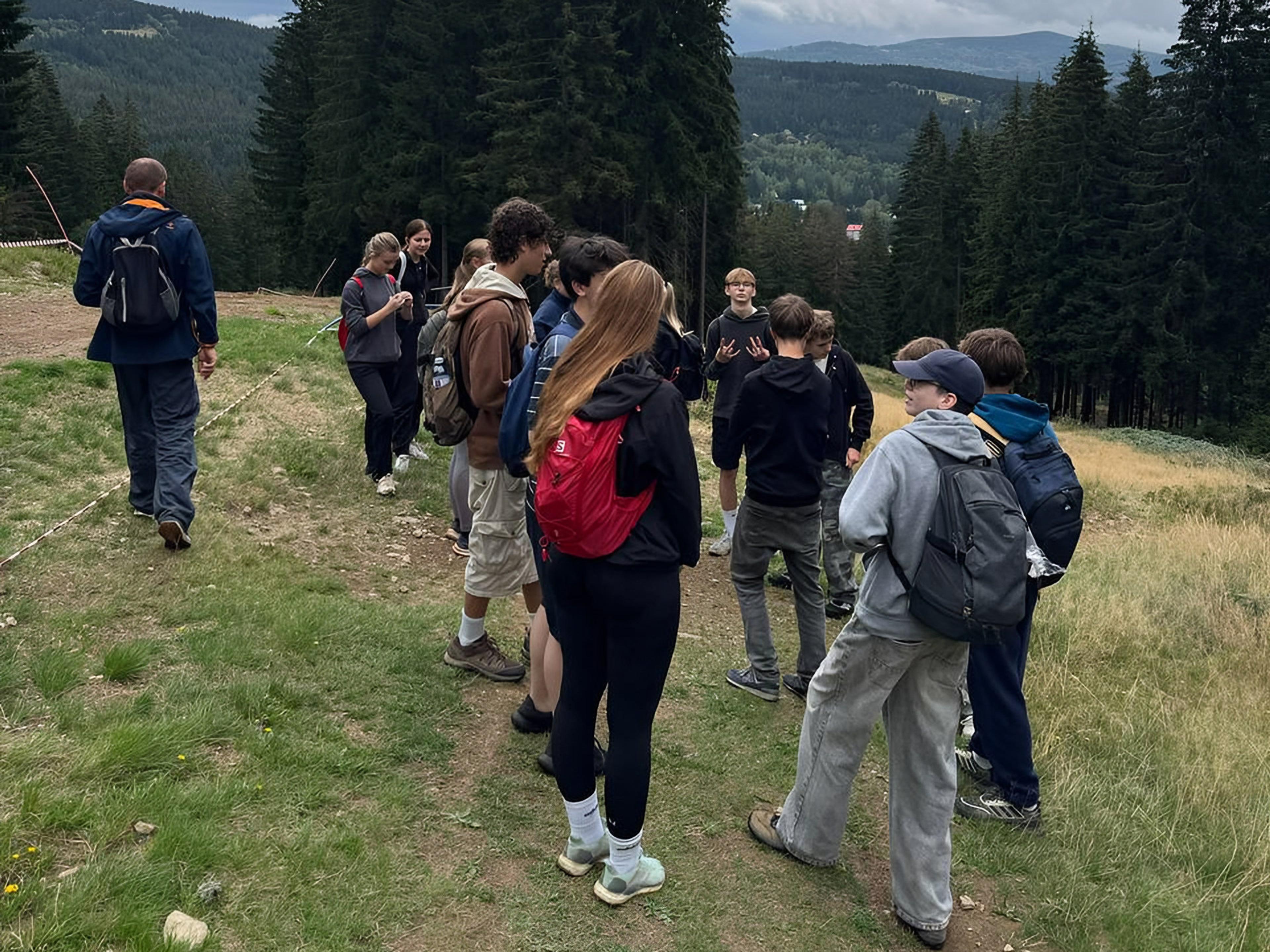 Studenti s učitelem na svahu s výhledem do šumavské krajiny