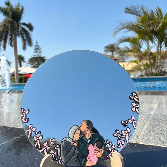 Custom hand-painted round mirror with a family portrait, poolside