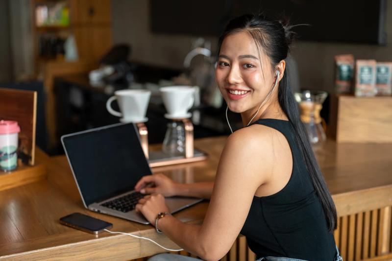 Asian marketer reviewing Meta Ads Manager analytics on a laptop
