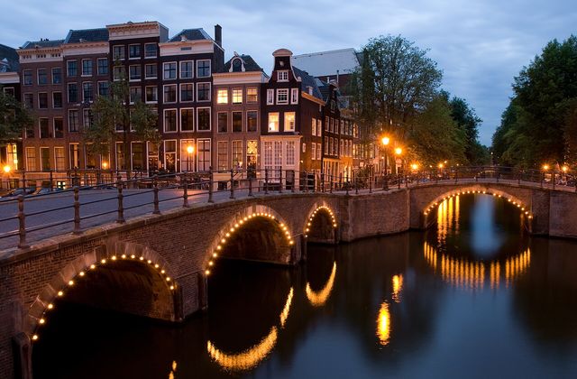 Canal houses and bridges at the corner of Keizersgracht and Reguliersgracht in Amsterdam at dusk