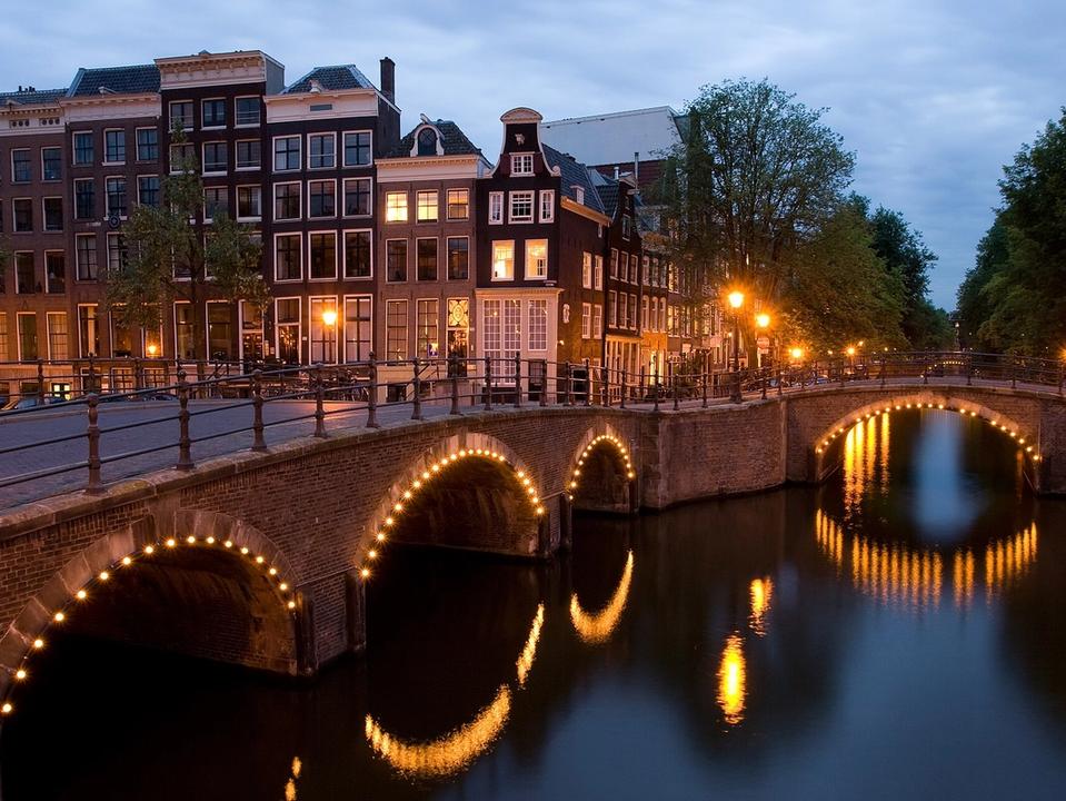 Canal houses and bridges at the corner of Keizersgracht and Reguliersgracht in Amsterdam at dusk
