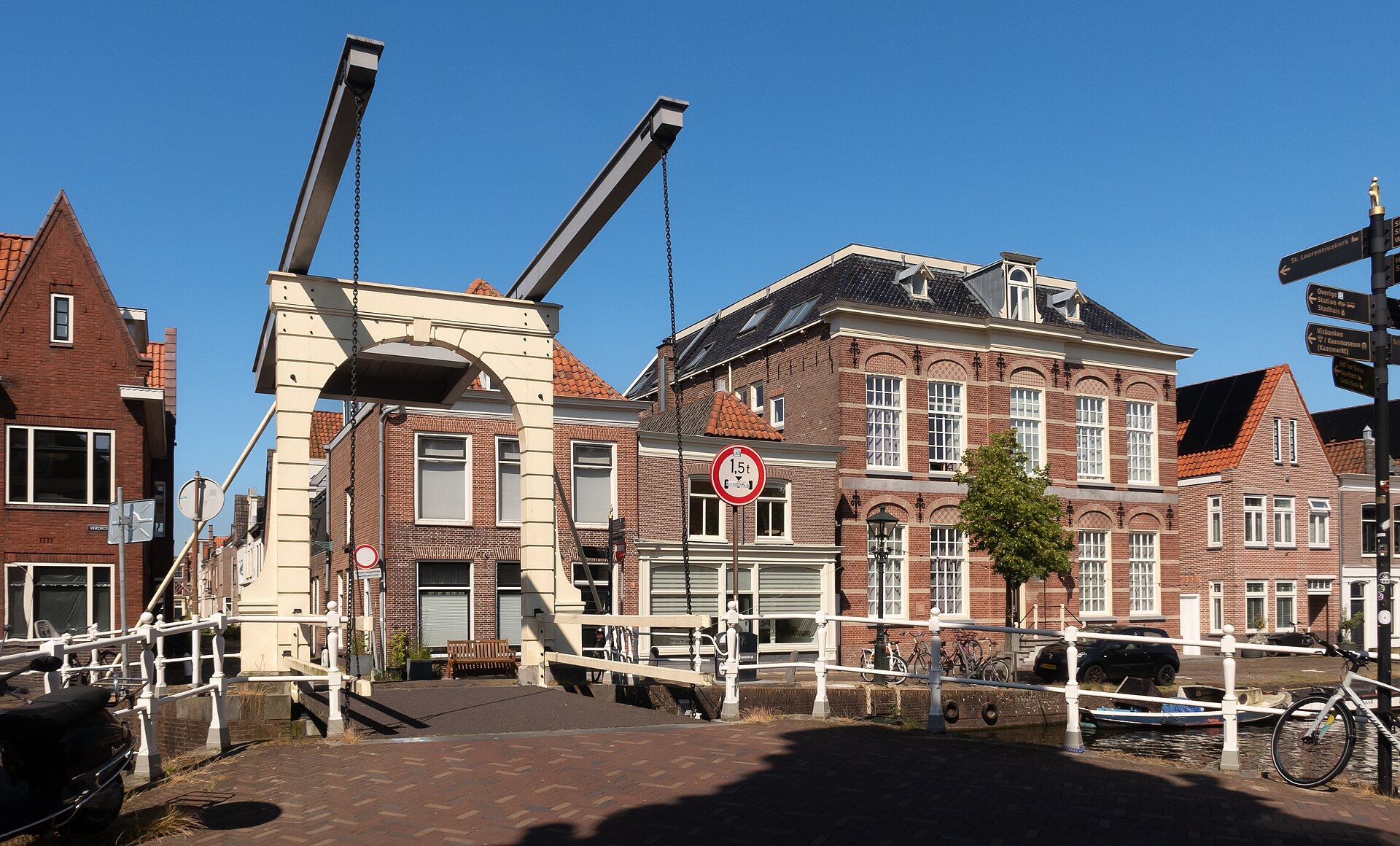 White drawbridge over the Verdronkenoord canal in Alkmaar with historic gabled houses and moored boats
