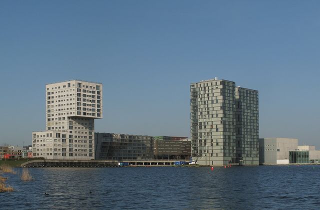 Modern high-rise skyline of Almere reflected in the Weerwater lake on a clear day