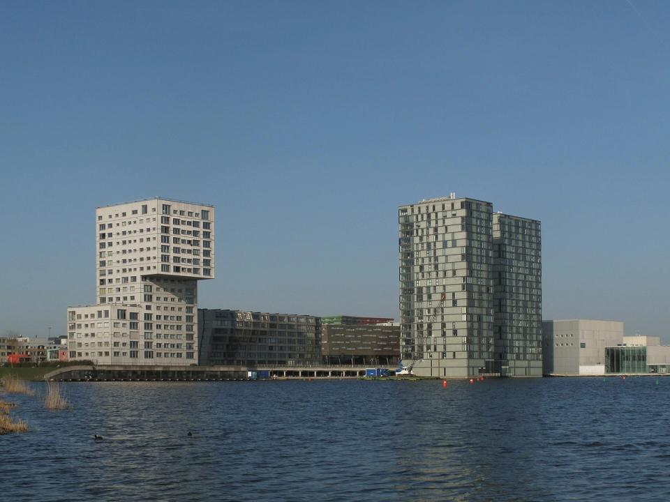Modern high-rise skyline of Almere reflected in the Weerwater lake on a clear day