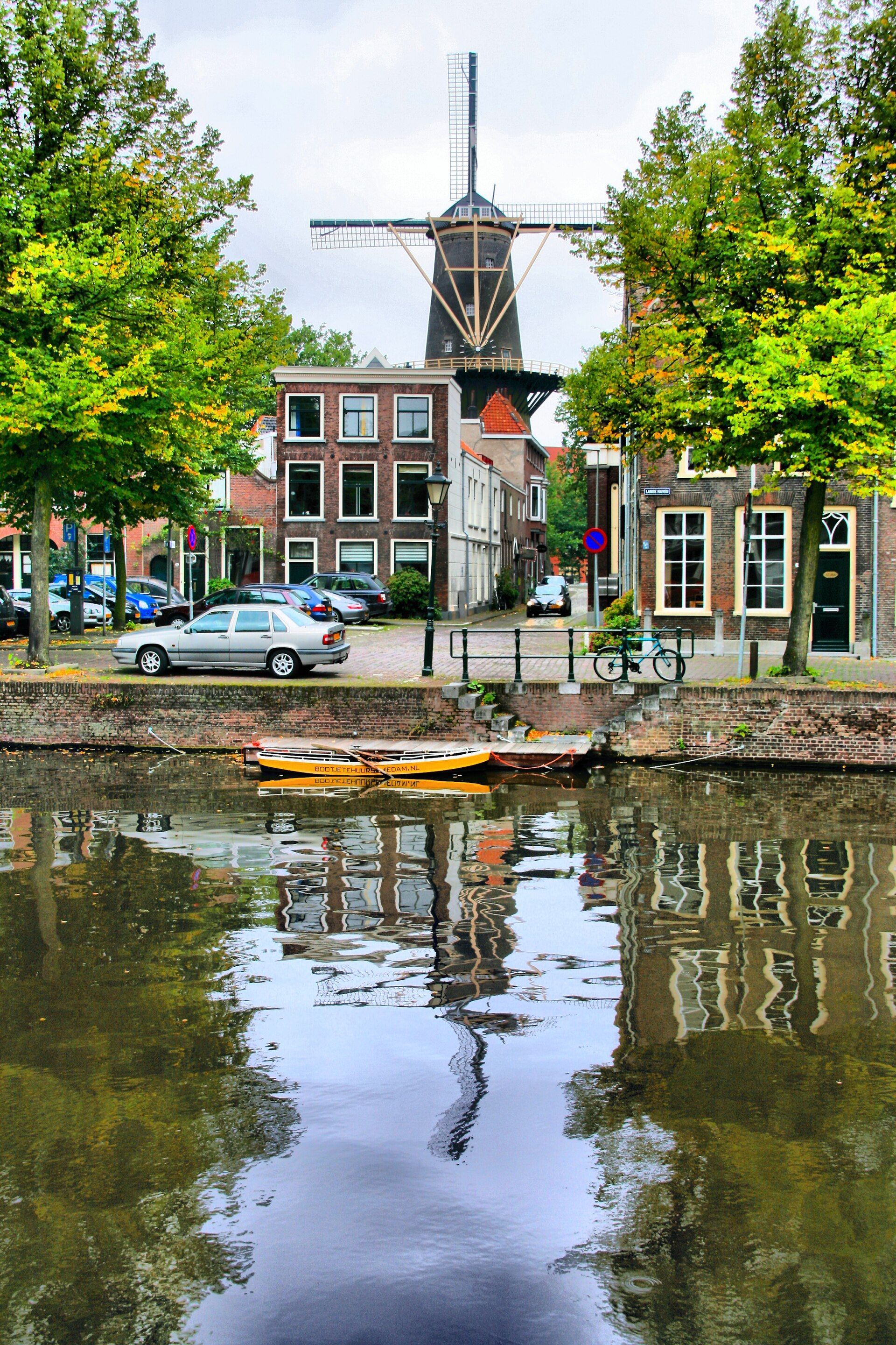 The historic windmill De Walvisch, one of Schiedam's giant mills, towering over a canal in the city centre