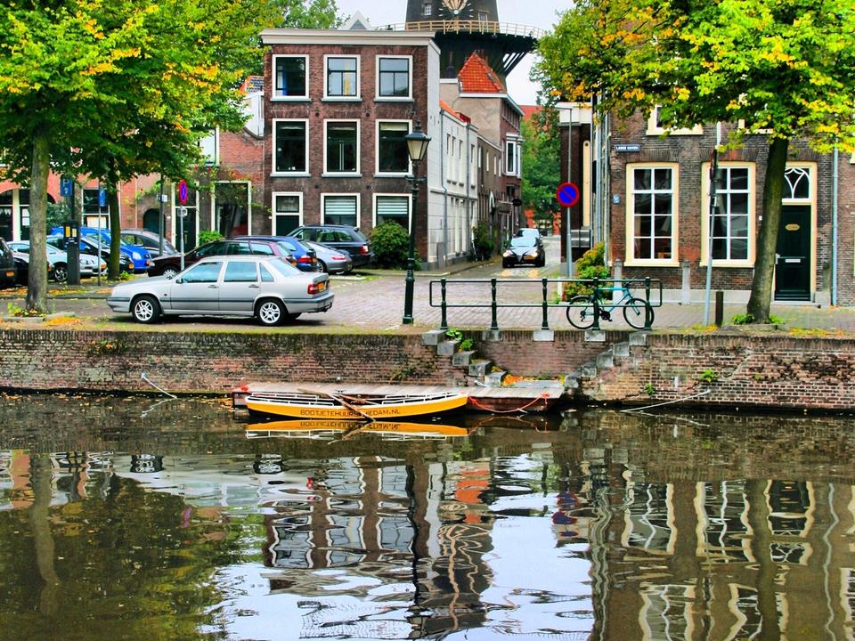 The historic windmill De Walvisch, one of Schiedam's giant mills, towering over a canal in the city centre